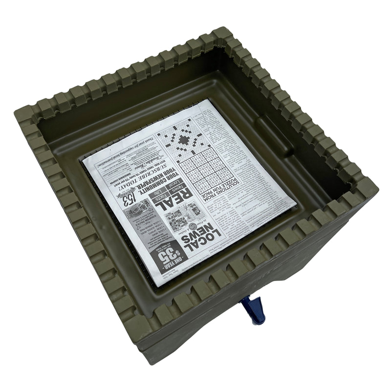 This image shows a stacking tray with a sheet of newspaper covering the mesh screen.